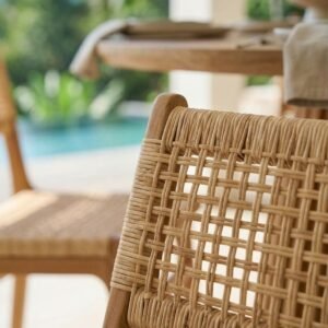 Teak dining furniture with woven chair backrest beside a luxury villa pool